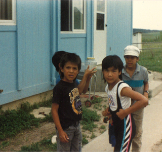 Shanti Zaid with Ft. Belknap friends outside of a house, c.1990