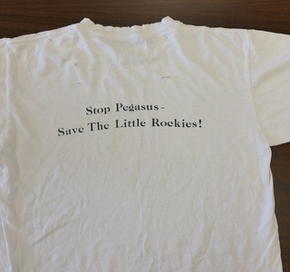 white tshirt with wriitng that says  stop pegasus save the little rockies