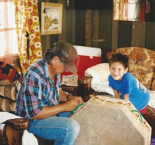 father and son inside of house with large drum on the floor