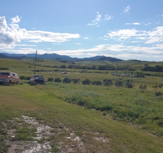  Cars in a field in mountain landscape