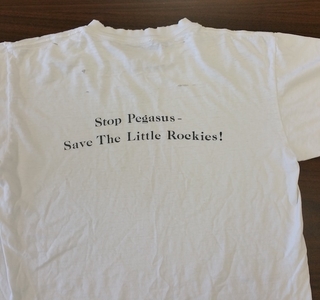 white tshirt with wriitng that says  stop pegasus save the little rockies